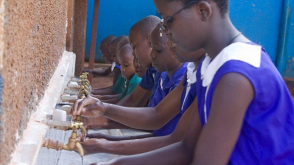 Children wash their hands before class begins at a school in Uganda.